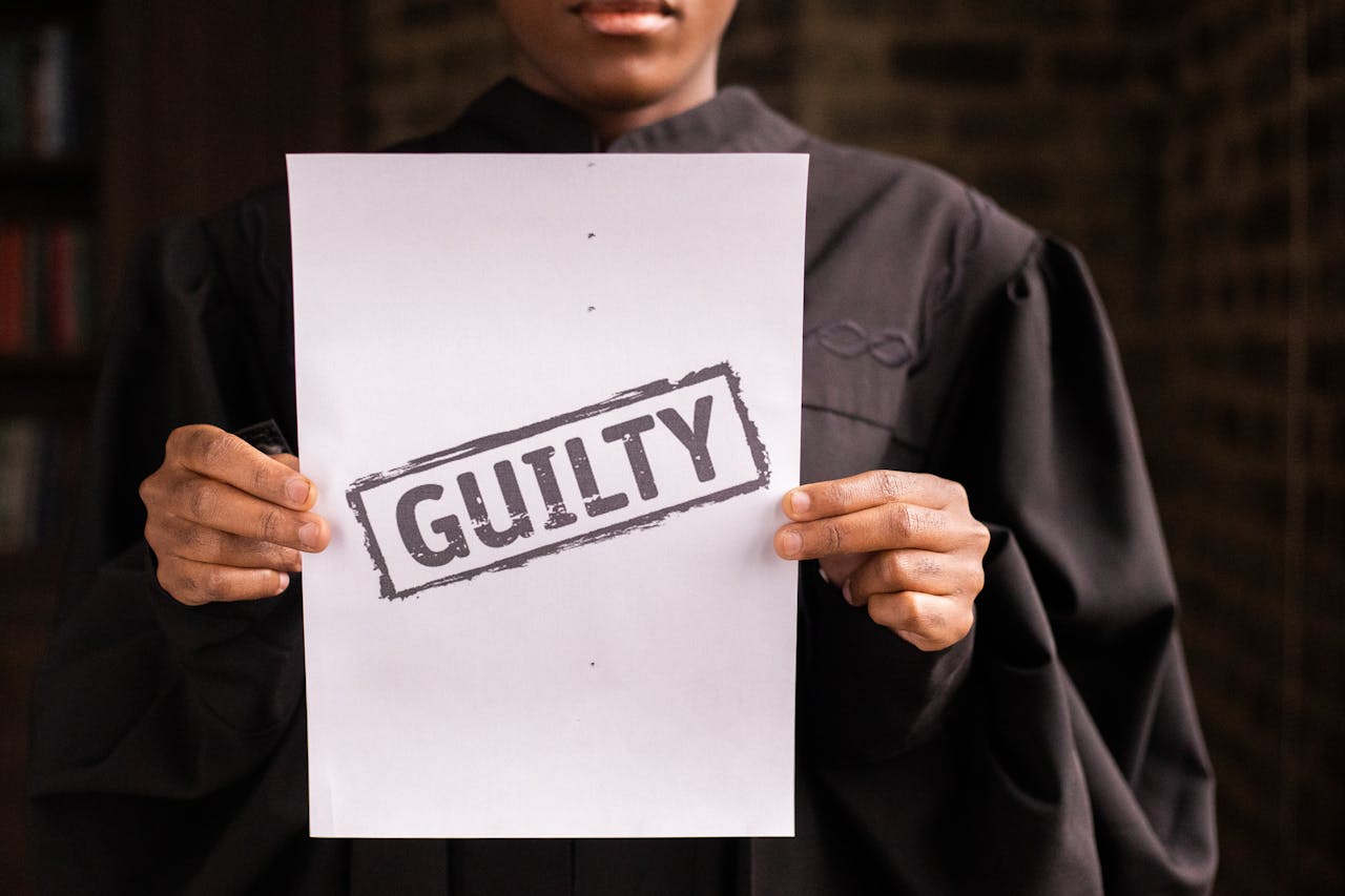 A judge in a courtroom holding a paper with a guilty verdict, symbolizing law and justice.